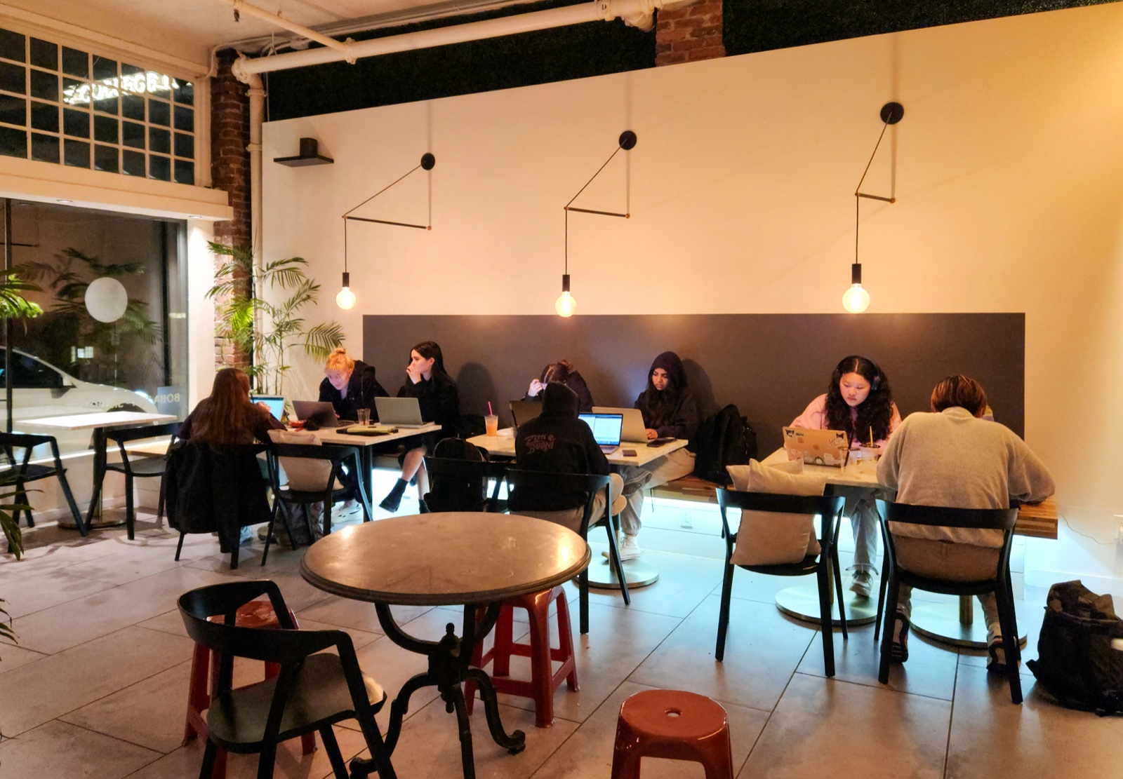 People working on laptops at a bright coffee shop